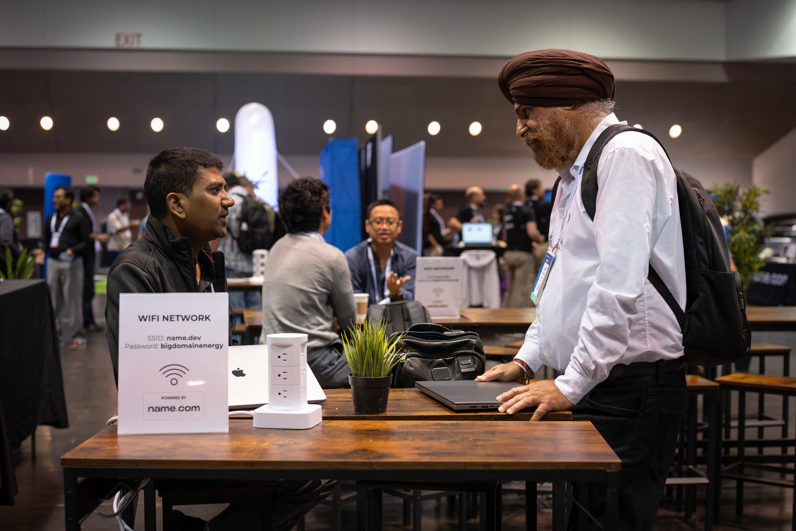 Deepak Gupta in a one-to-one conversation with an attendee at a table on the API World expo floor